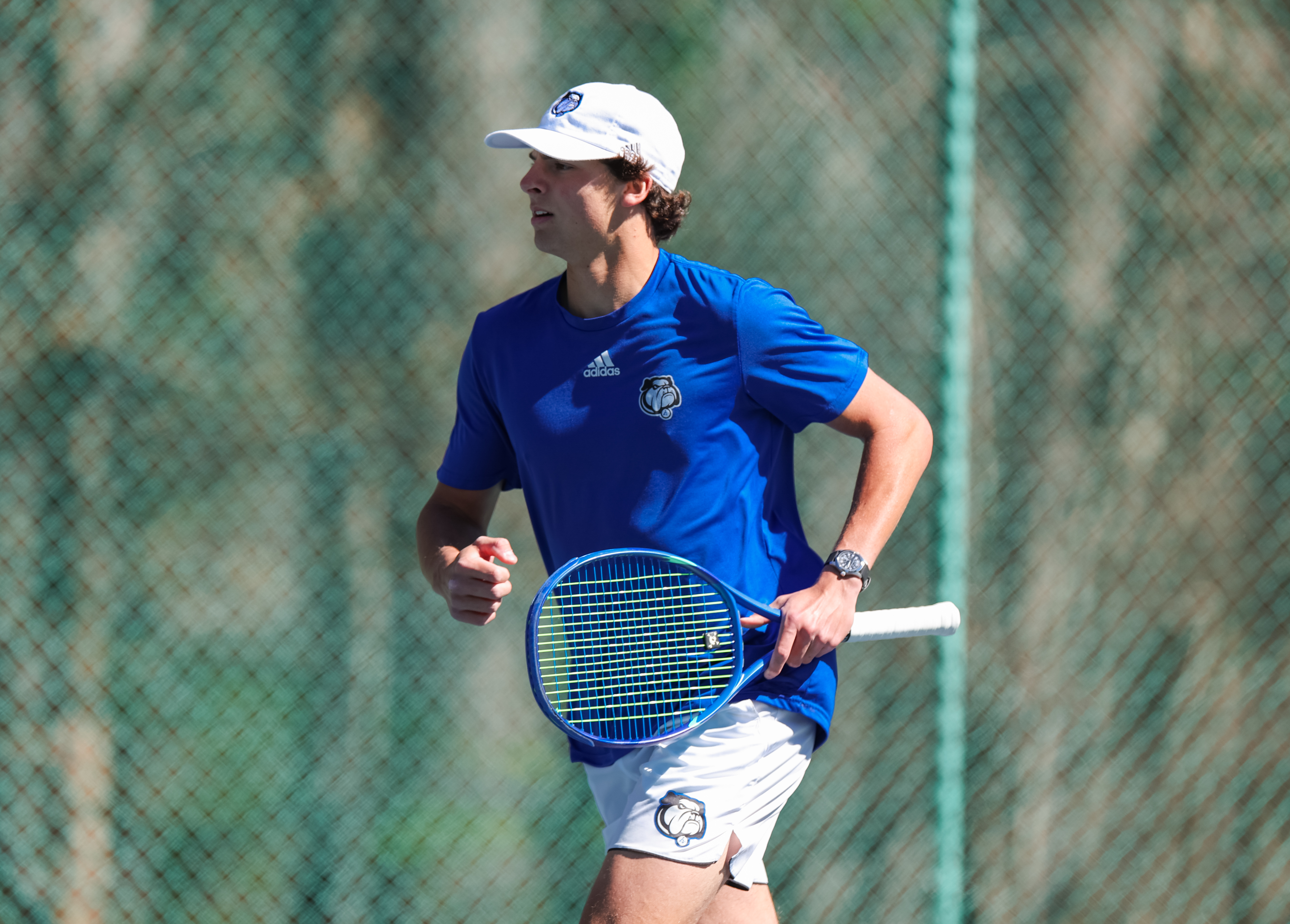 Trevor Gray moving on court in a UNC Asheville tennis kit.